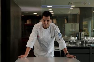Diego Gallegos at Sollo with kitchen in background